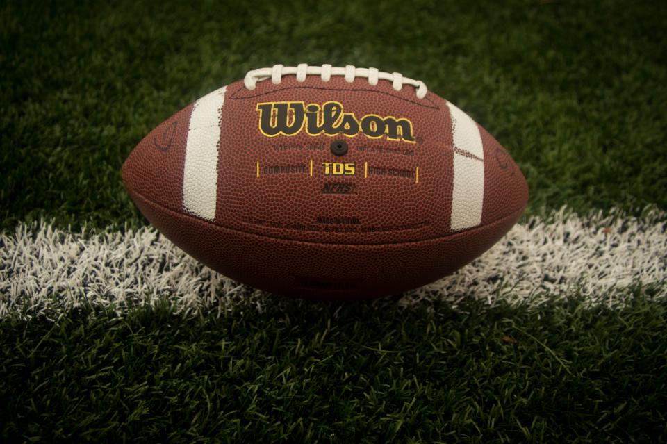 Football resting on the grass of a playing field