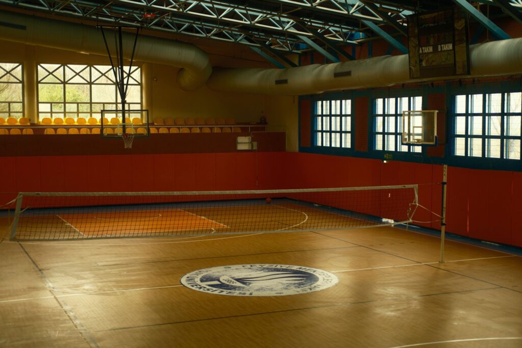 Indoor volleyball net on an empty wooden gymnasium court